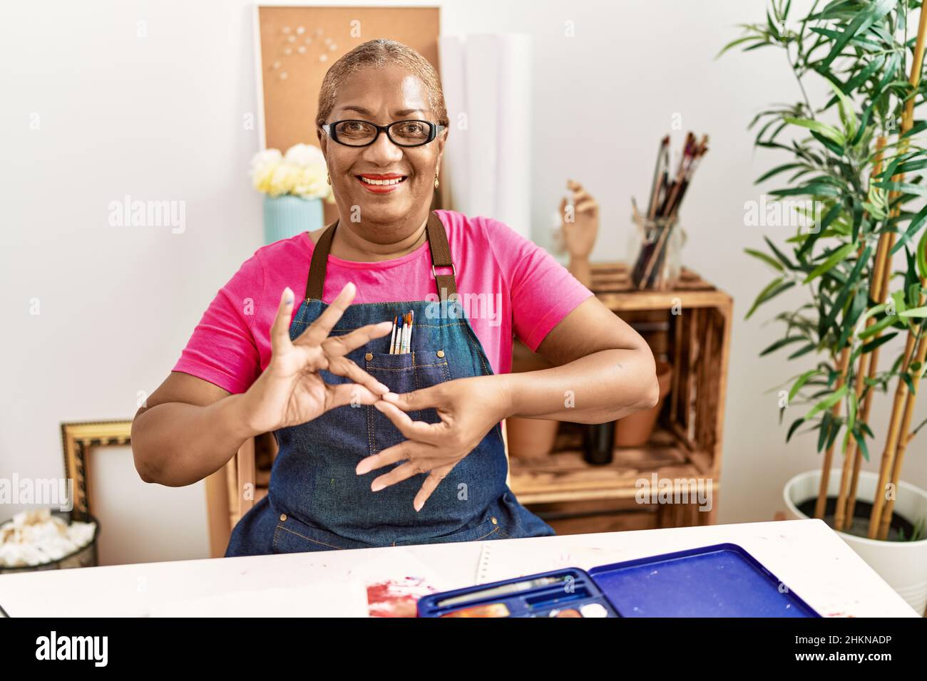 Senior african american woman communicating with deaf language at art studio Stock Photo