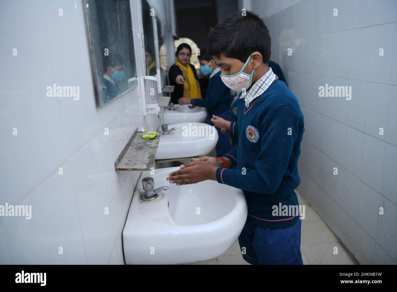 Students of Umakanta English Medium school sanitize their hands before entering on the first day of reopening of schools. Schools were closed due to COVID-19 in Agartala. India. Stock Photo
