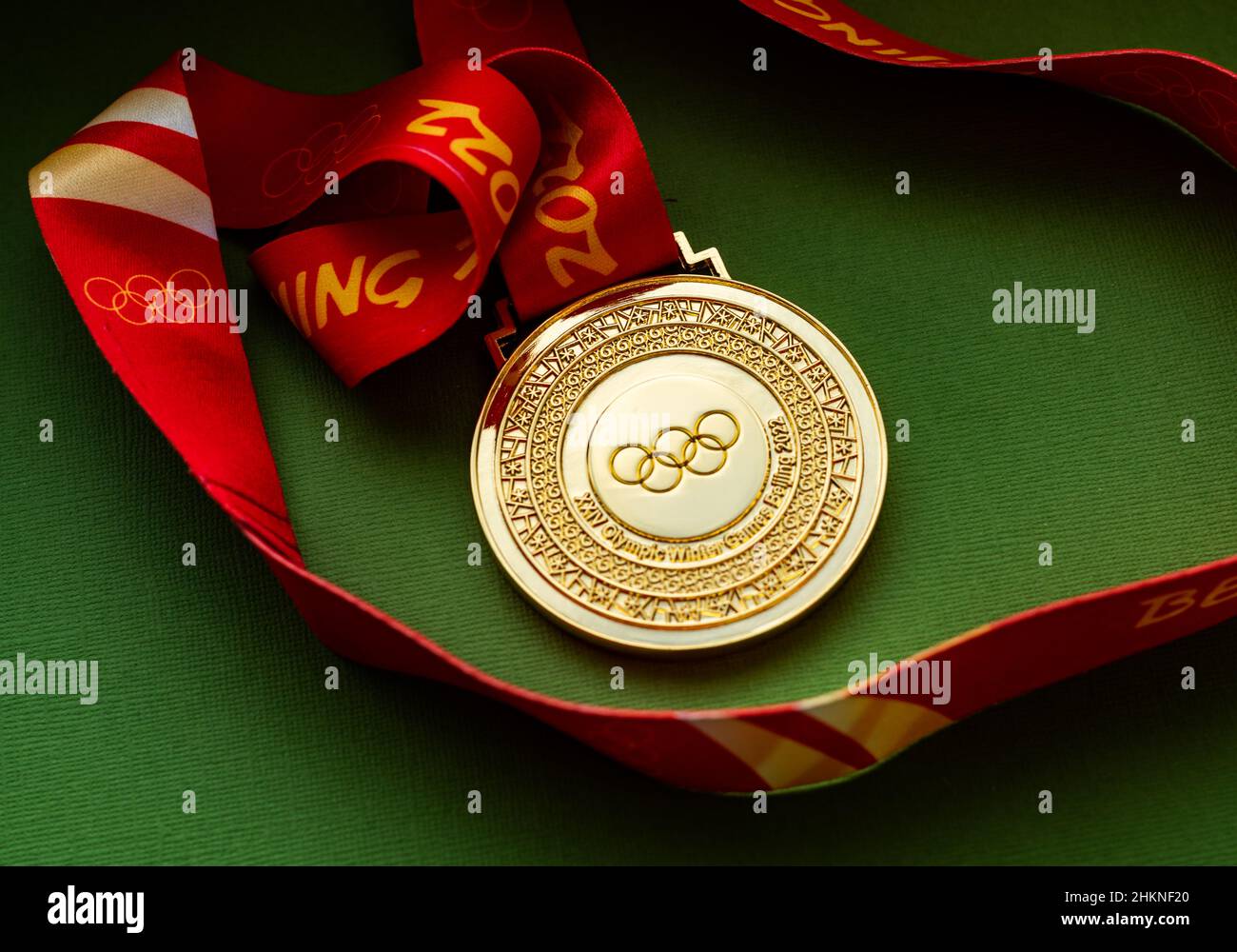 January 27, 2022, Beijing, China. XXIV Olympic Winter Games gold medal on a green background. Stock Photo