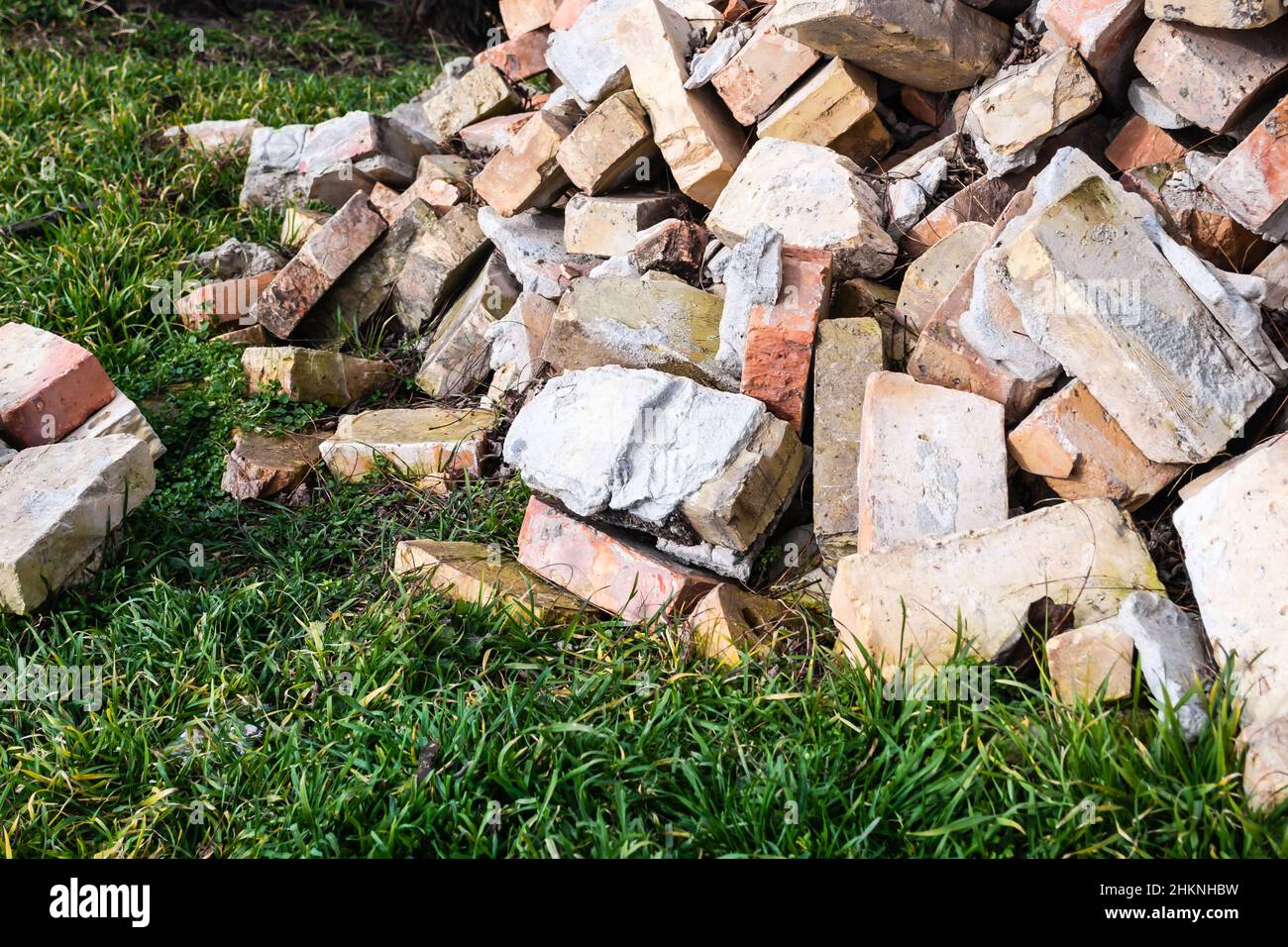 A pile of old used bricks with scratches and cracks from the old wall