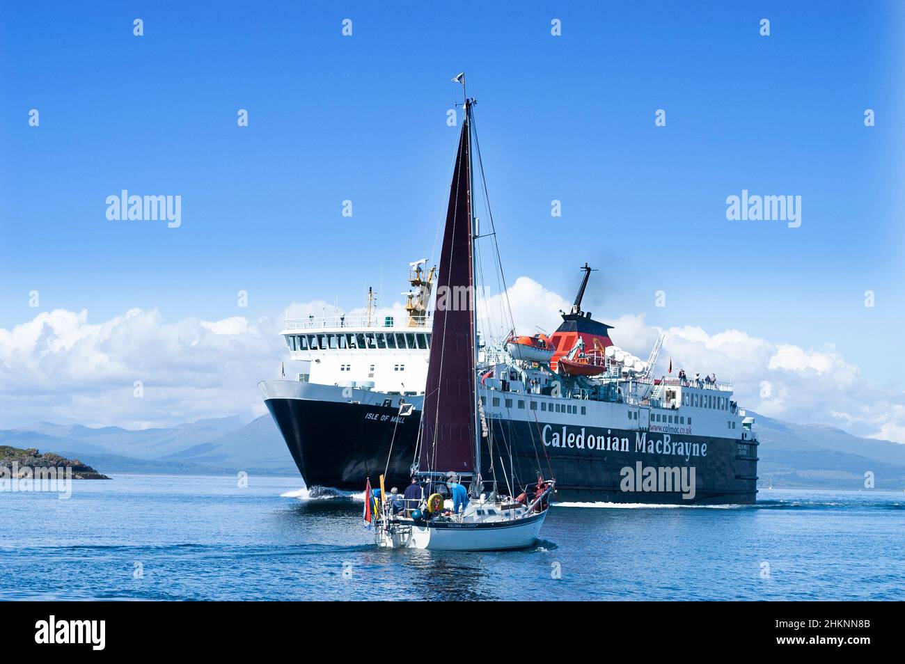 Yacht passing the Caledonian MacBrayne ferry outside the port of Oban on the west coast of Scotland, UK Stock Photo