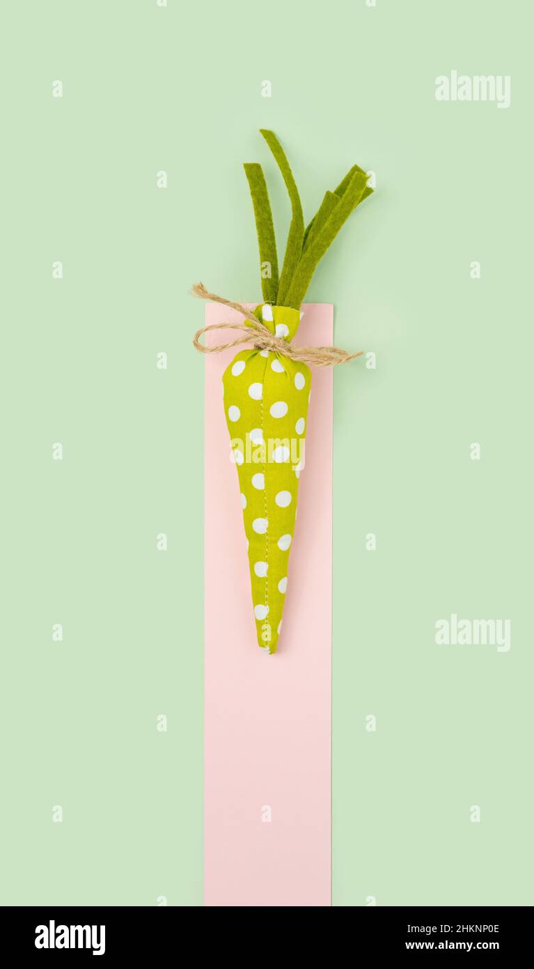 Green  ornament carrot on a pastel background. Happy Easter minimal flat lay. Stock Photo