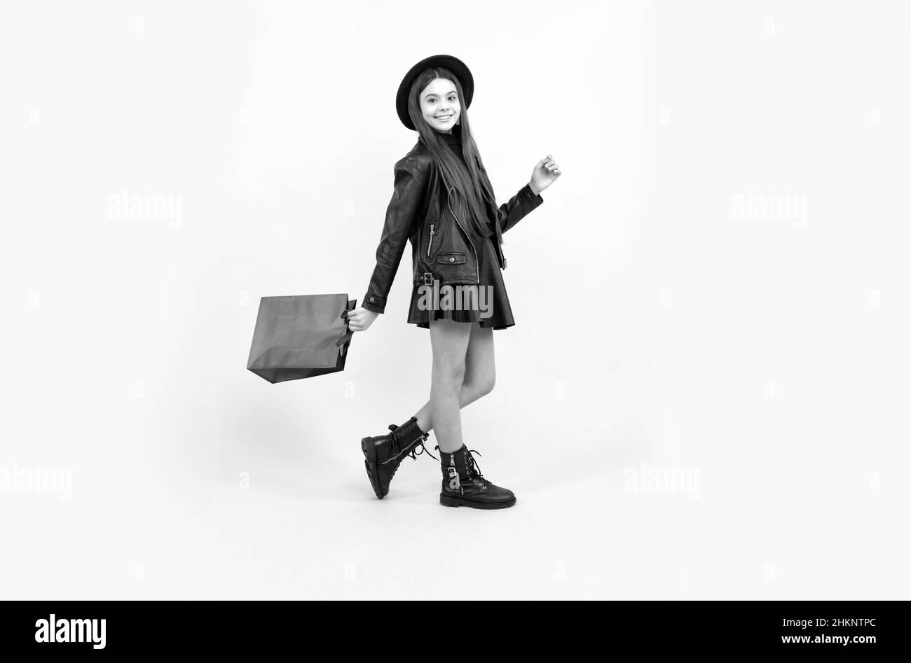 happy teen girl in hat and leather clothes hold shopping bag, shopping sale Stock Photo