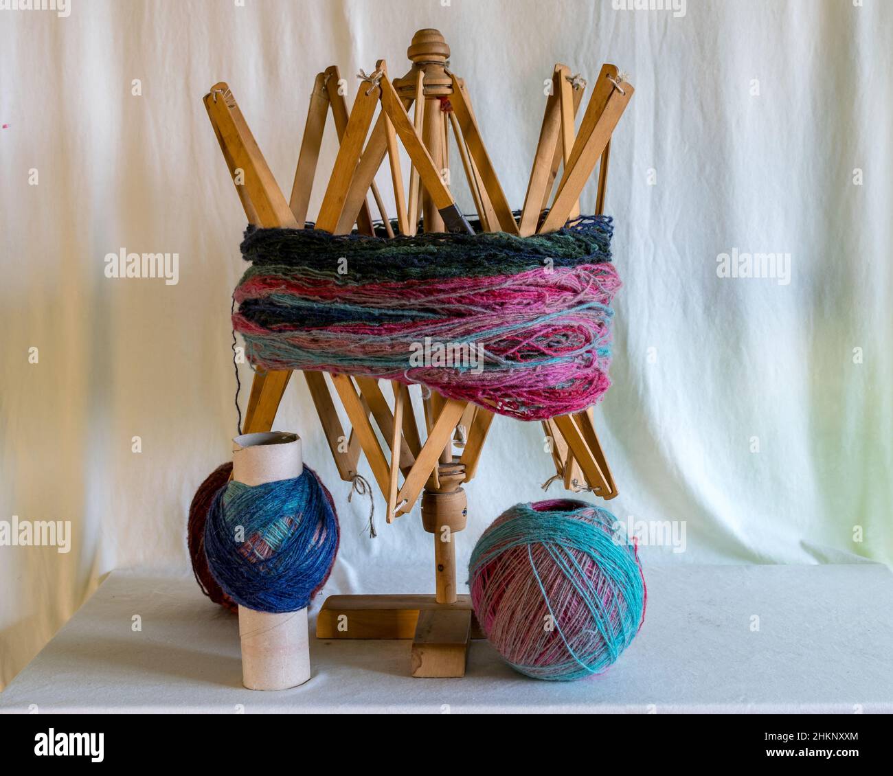 yarn is placed on the legs of a chair so that you can roll a ball, the old-fashioned method, knitting as a hobby, a good way to spend free time is han Stock Photo