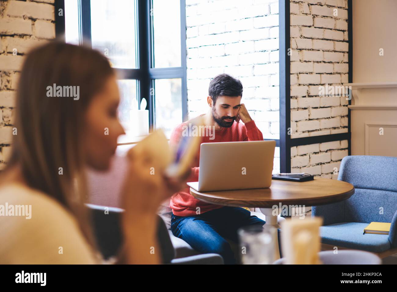 Pensive freelancer working on laptop in cafe Stock Photo