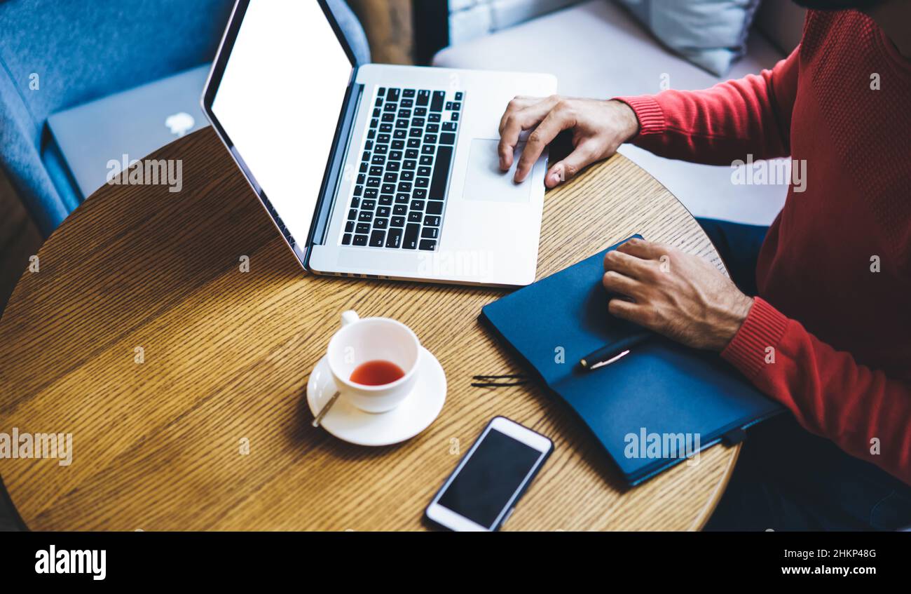 Freelancer working on laptop in cafe Stock Photo