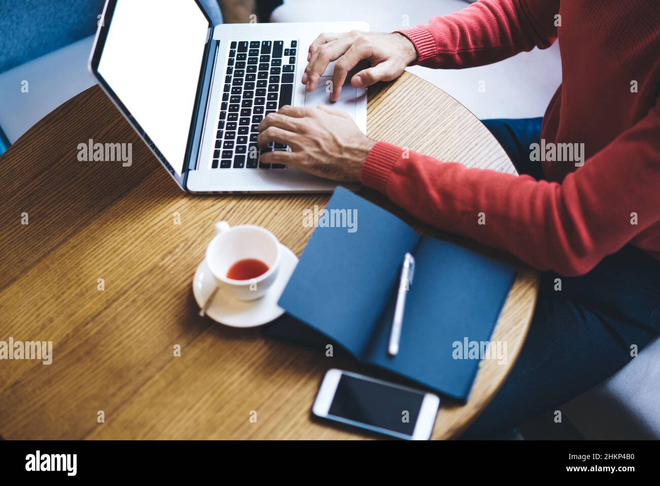 Crop freelancer working on laptop in cafe Stock Photo