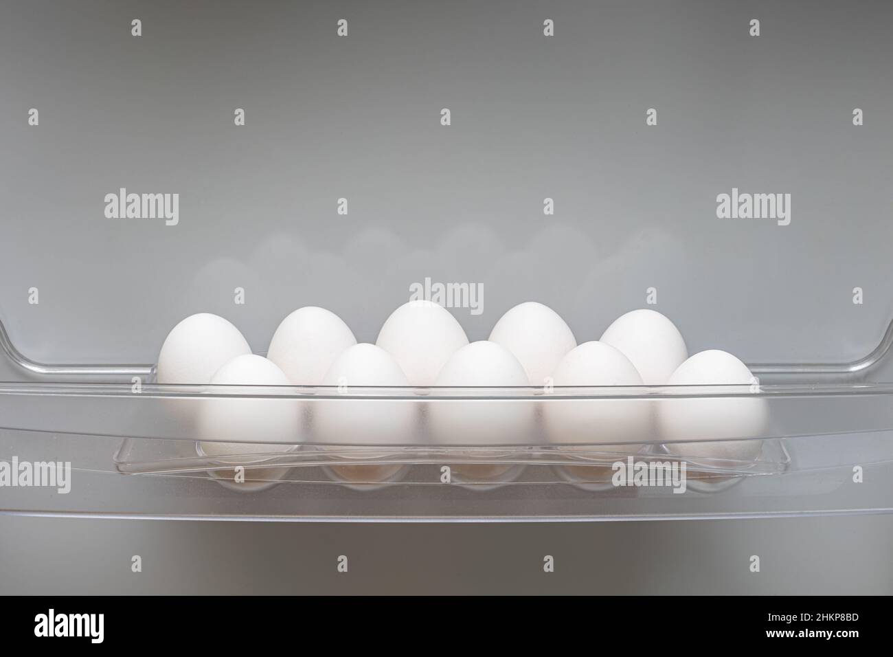 a dozen fresh eggs lie in a special compartment of the refrigerator Stock Photo