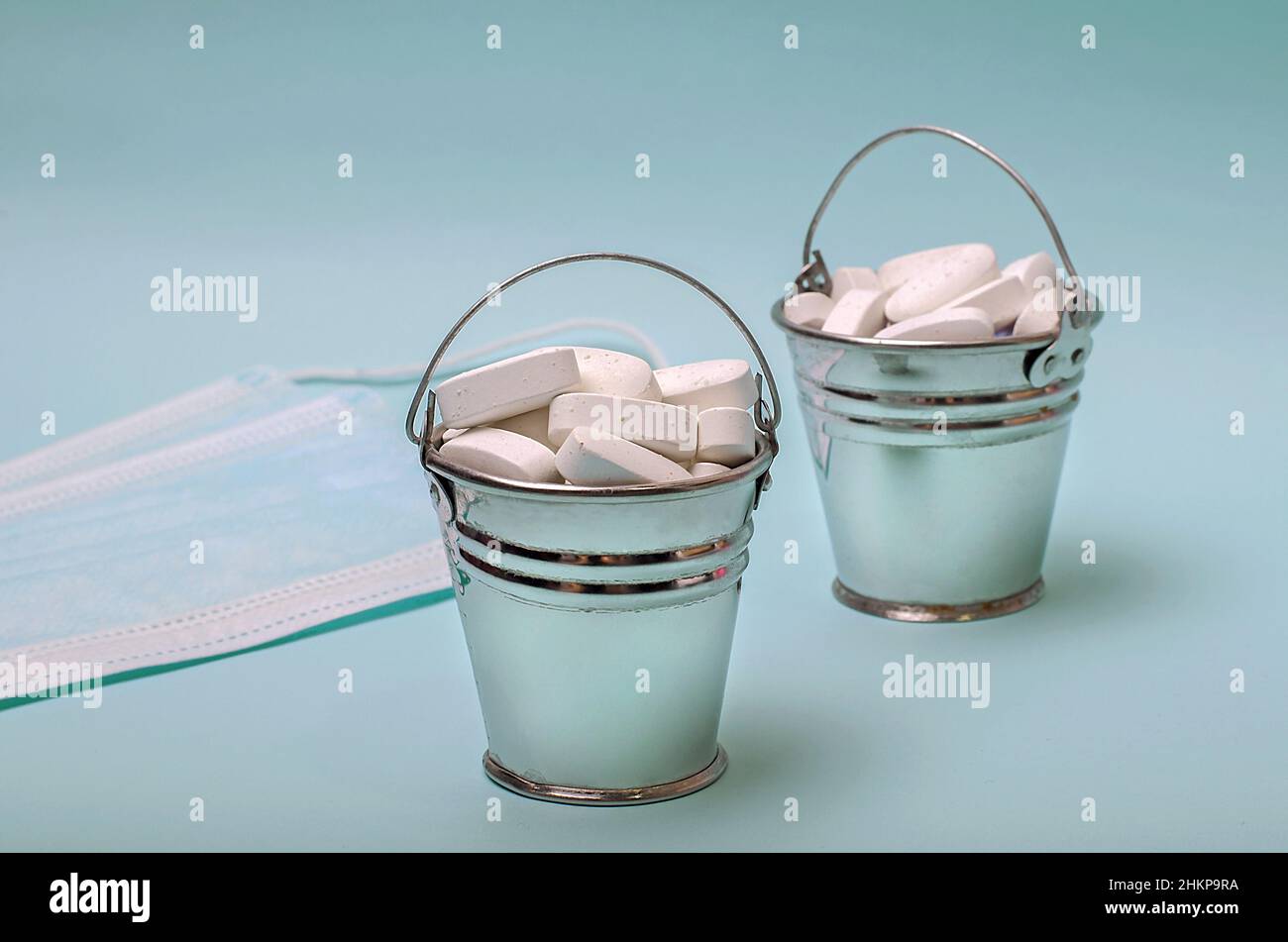 Miniature small buckets filled with pills Stock Photo