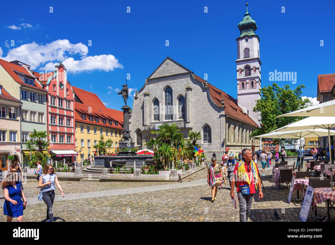 Lindau in Lake Constance, Bavaria, Germany, Europe: Bustling market square scene in front of Neptune Fountain and Church of St. Stephan. Stock Photo