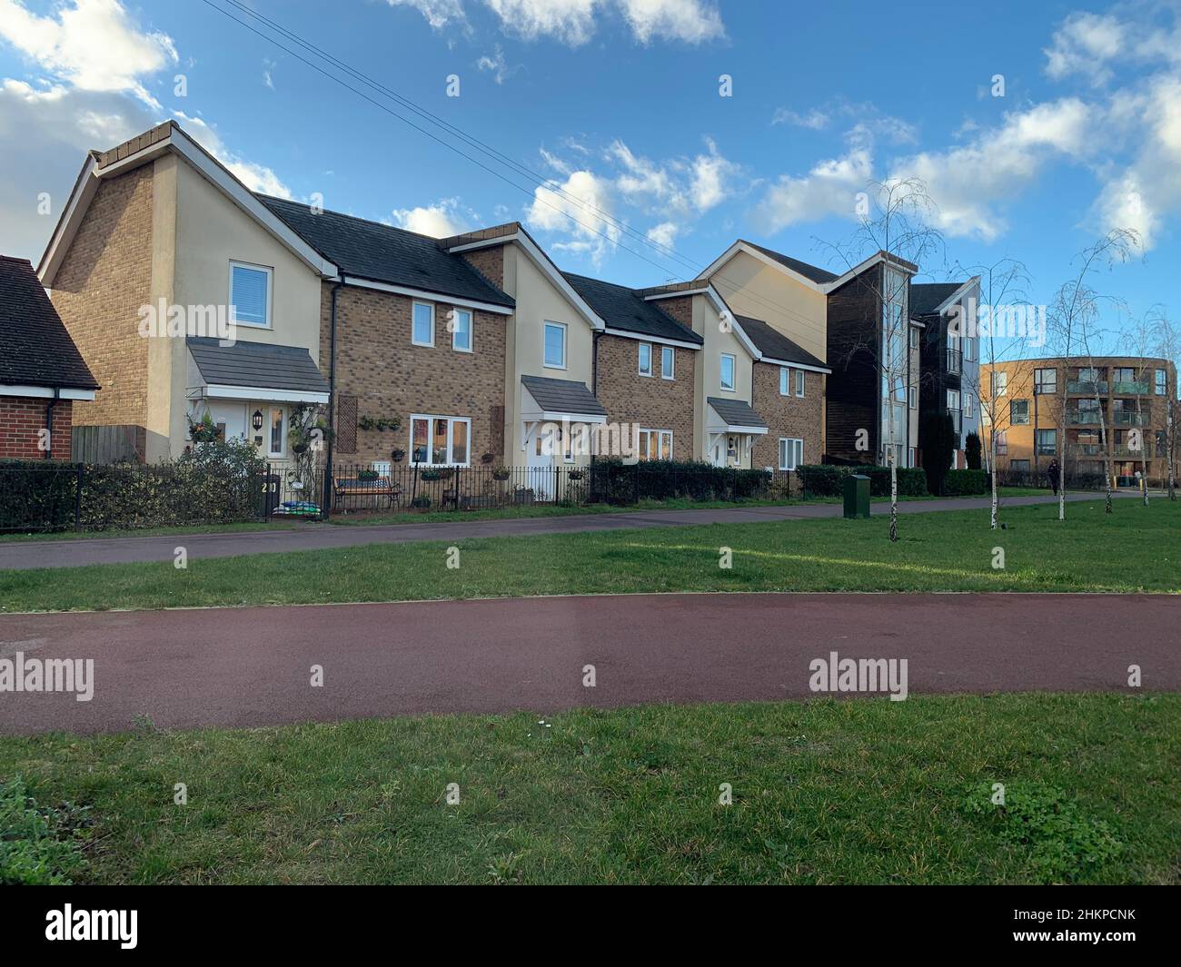 Houses and flats in Milton Keynes UK railings grass roof trees clouds