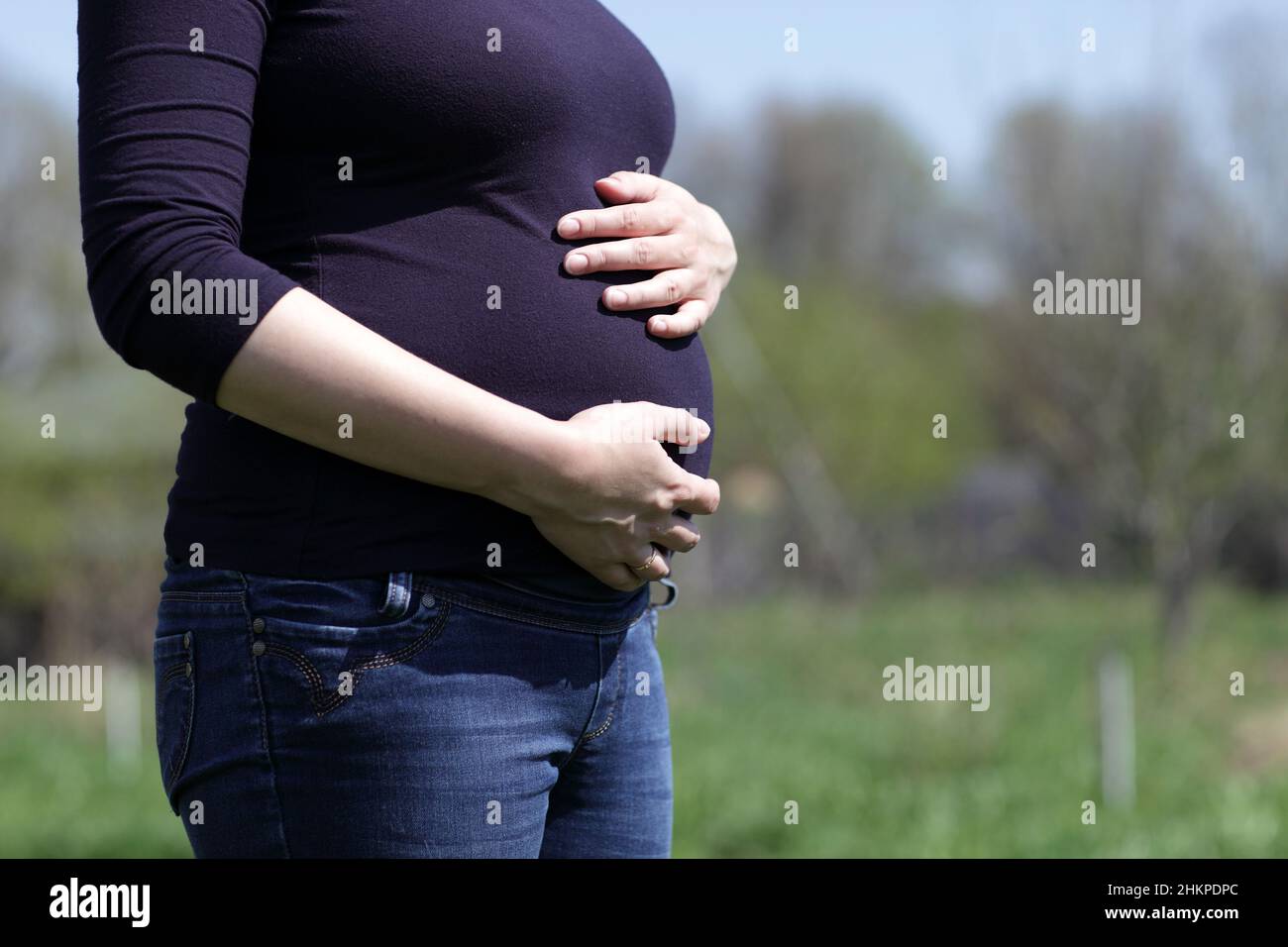 The pregnant woman holds her belly outdoor Stock Photo - Alamy