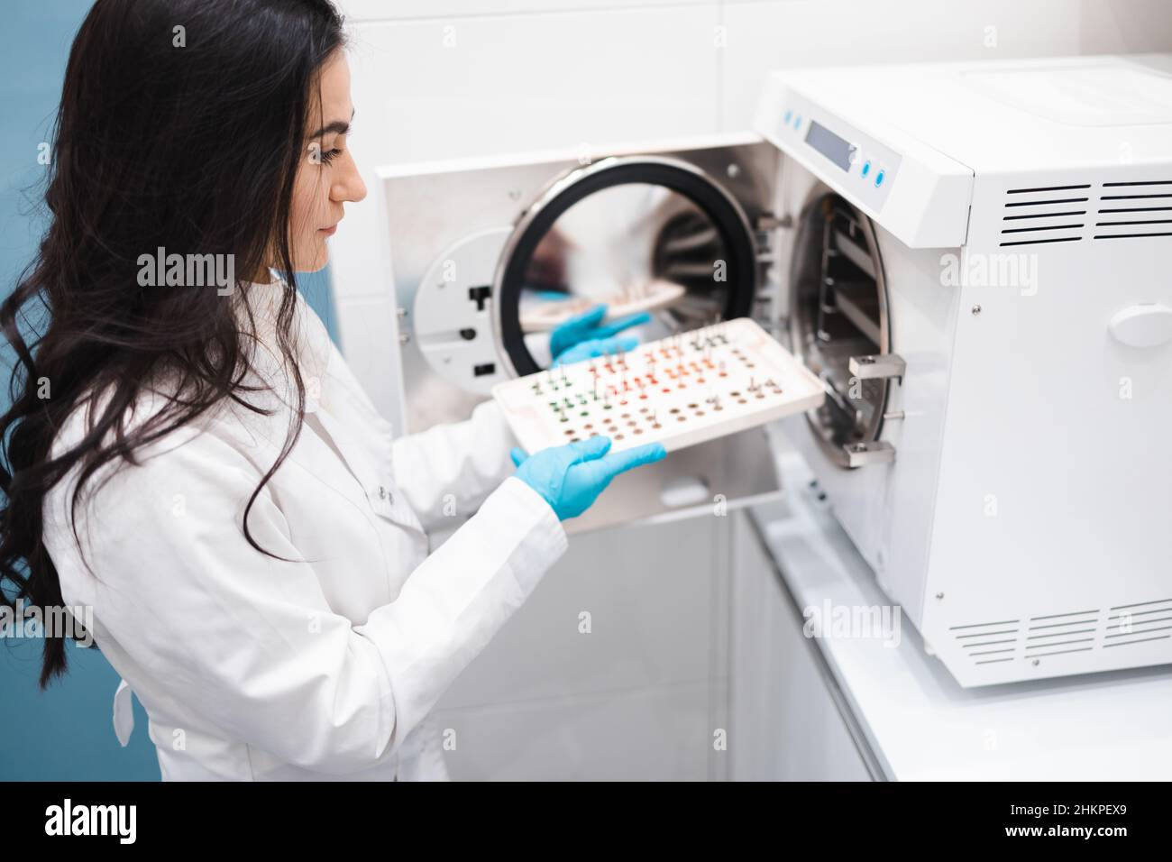 Female dentist assistant putting instruments for dental implantation