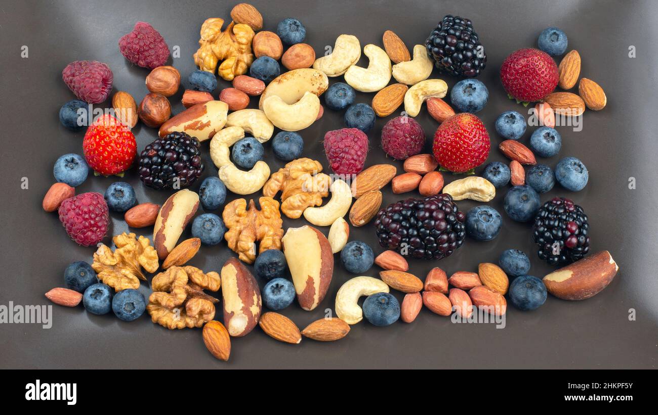 different berries and nuts on a plate. vitamin proteins and healthy
