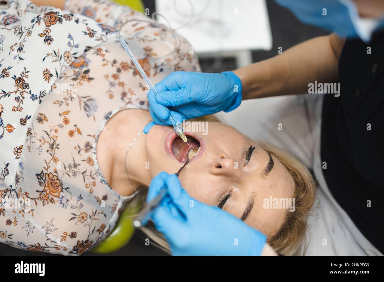 Doctor giving painkiller injection to woman patient using dental