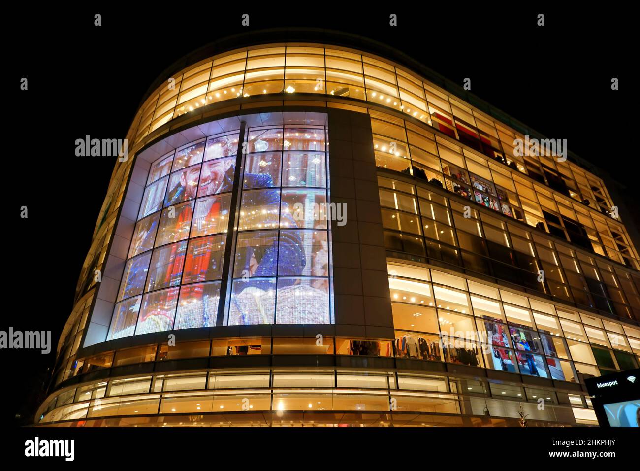 Illuminated modern glass building with advertising screen of the clothing department store Peek & Cloppenburg in Düsseldorf/Germany. Stock Photo