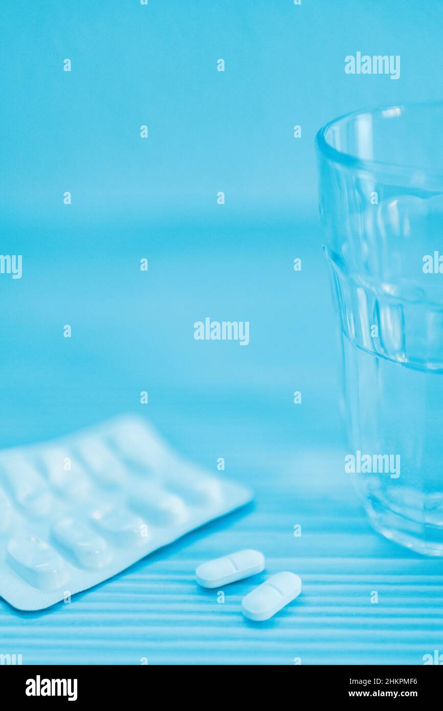 Close up of a glass of water and tablets  on table Stock Photo