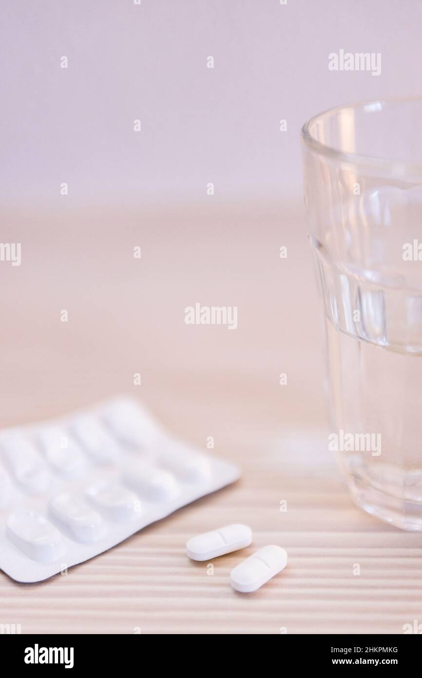 Close up of a glass of water and tablets  on table Stock Photo