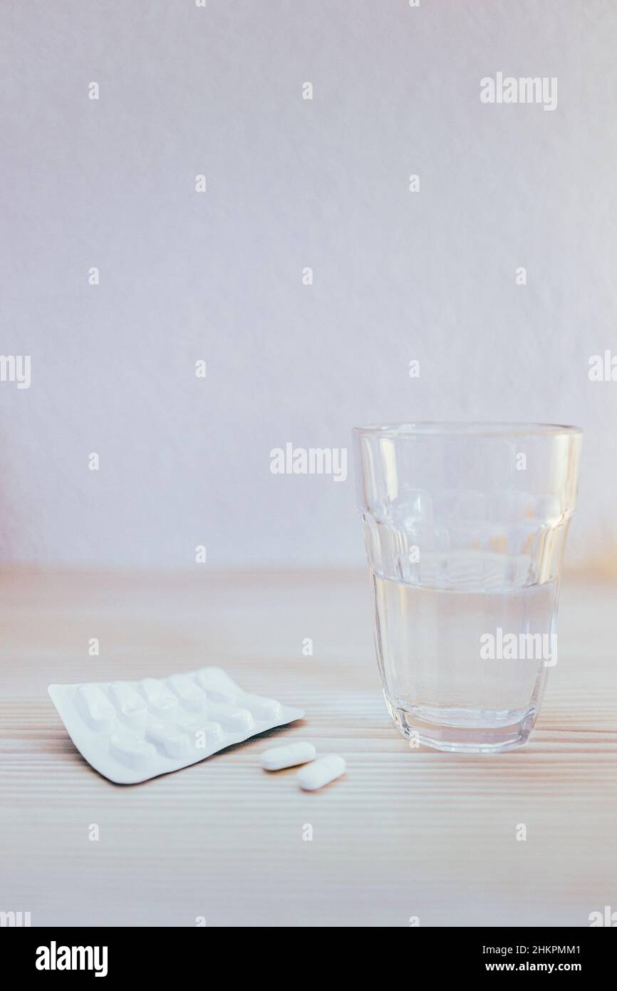 Glass of water and tablets  on table Stock Photo