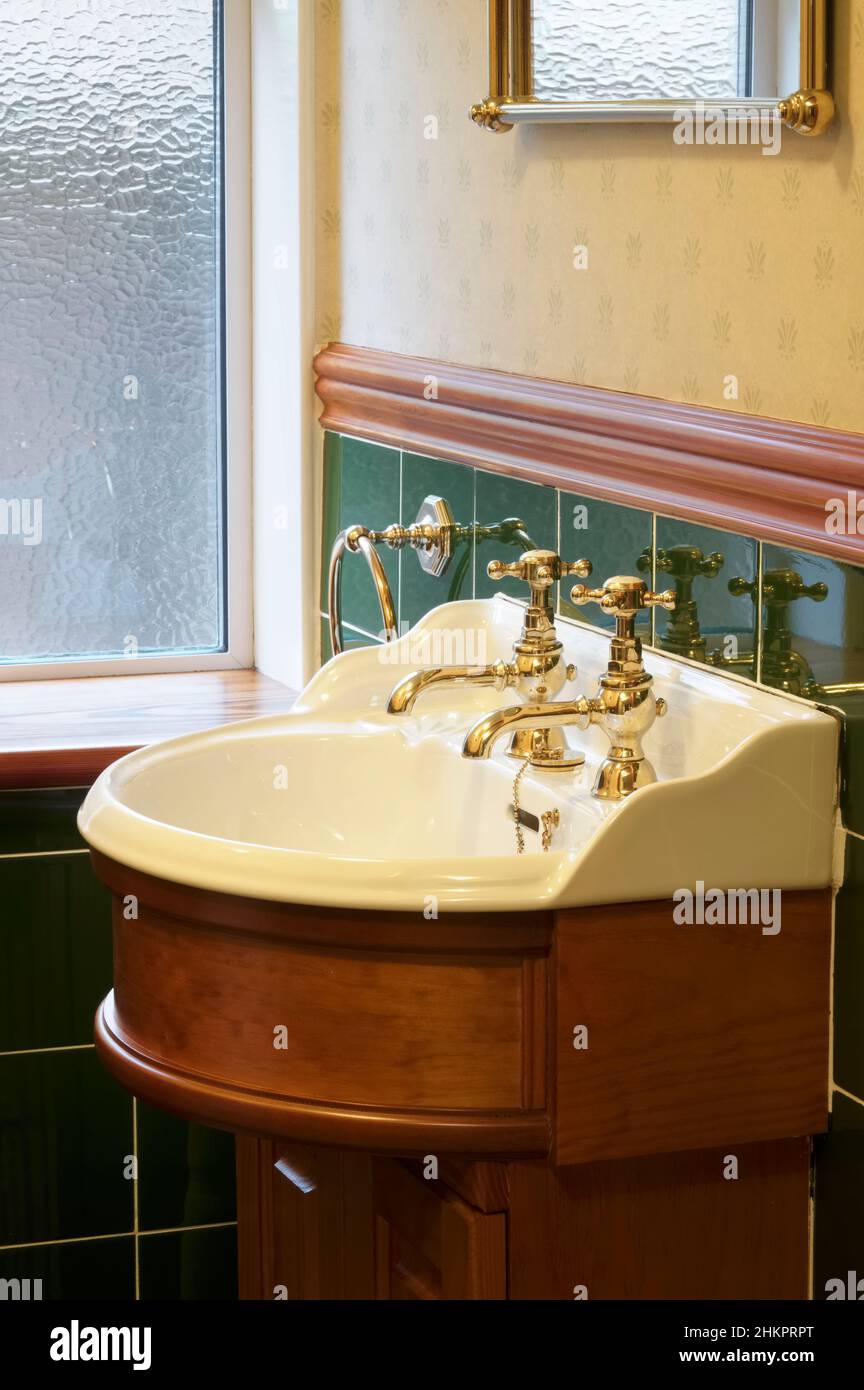 New luxury hotel vintage brass gold plated pillar taps in ensuite bathroom at wash basin Stock Photo