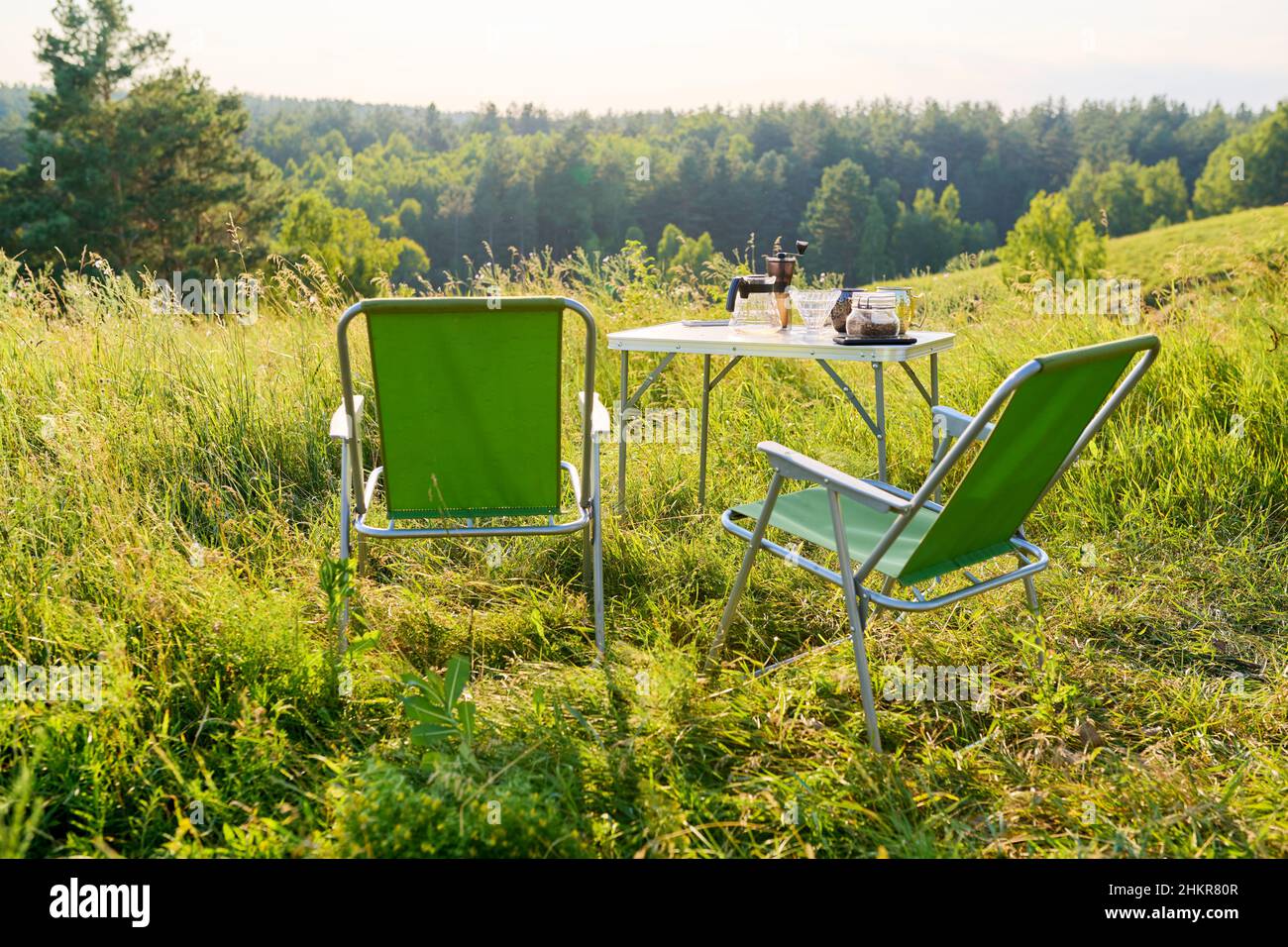 Set of folding furniture for camping, table and chair, summer nature of wild meadow Stock Photo