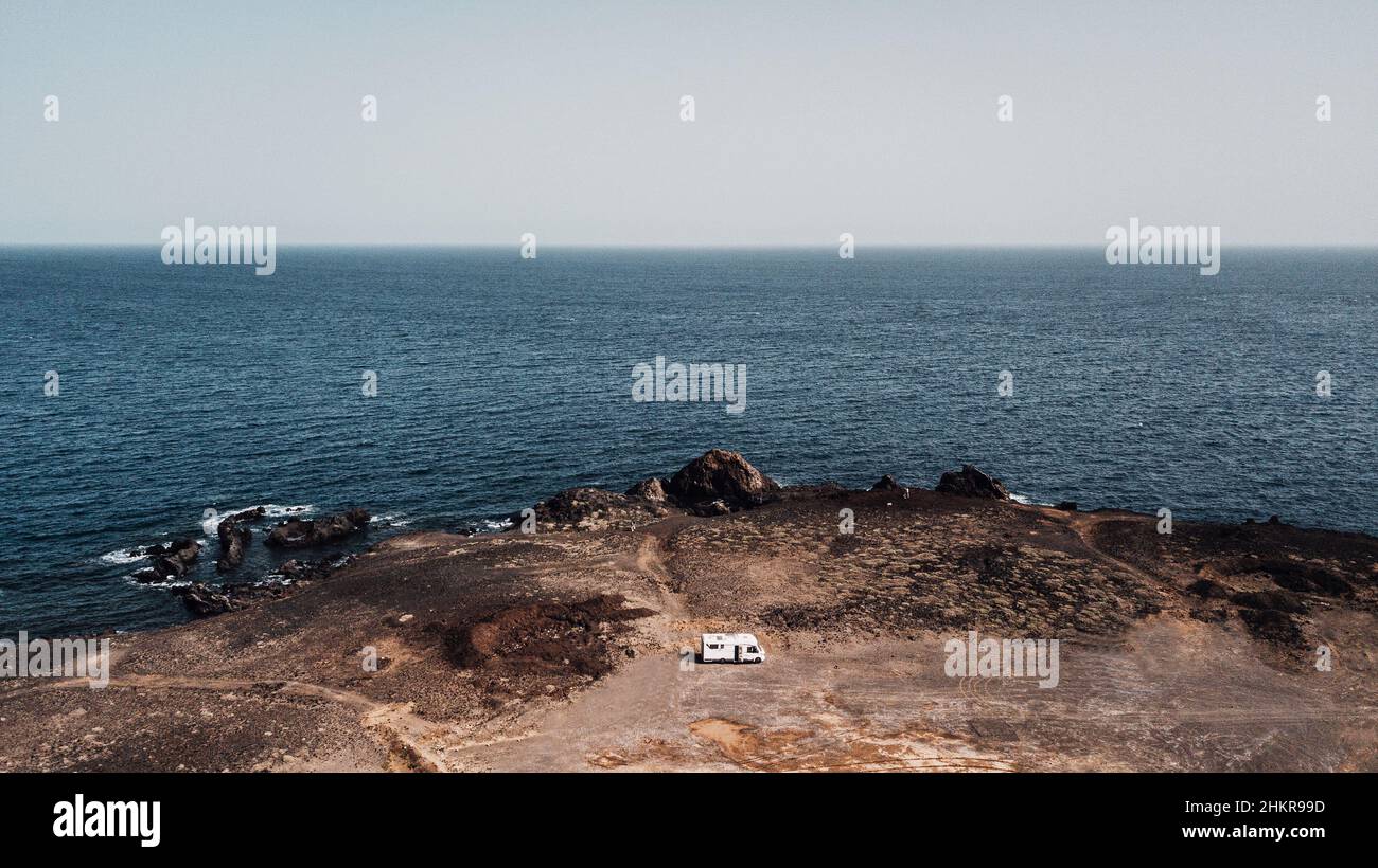Camper van parked on the coast with blue sky and ocean water in ...