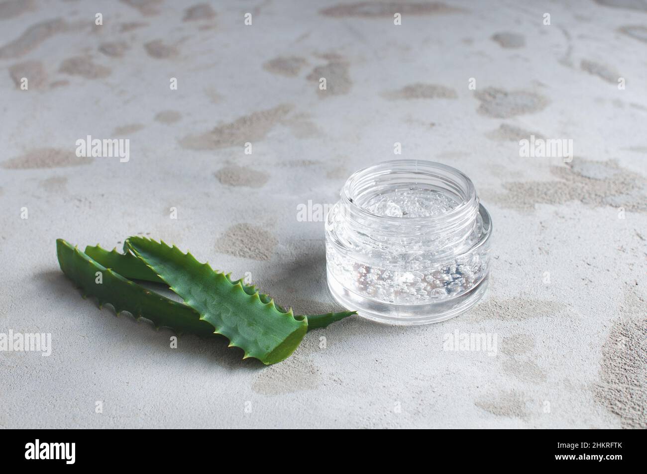 transparent jar with moisturizing cream with hyaluronic acid on a concrete background Stock Photo