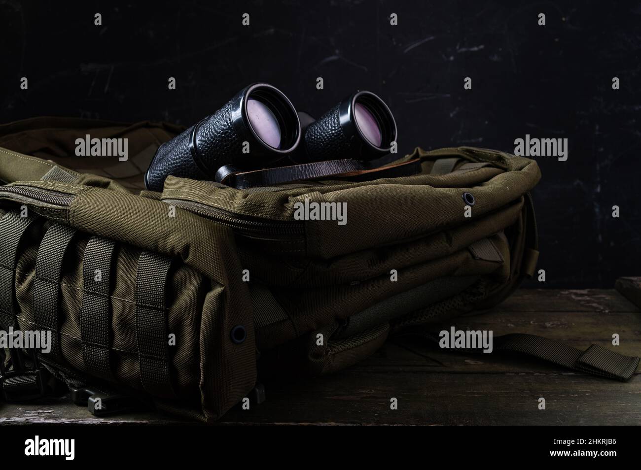 Military backpack and binoculars. Watch and observe through binoculars. Military concept Stock