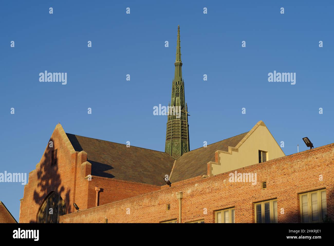 Rooftop and steeple of the First United Methodist Church against a blue, afternoon sky. Stock Photo