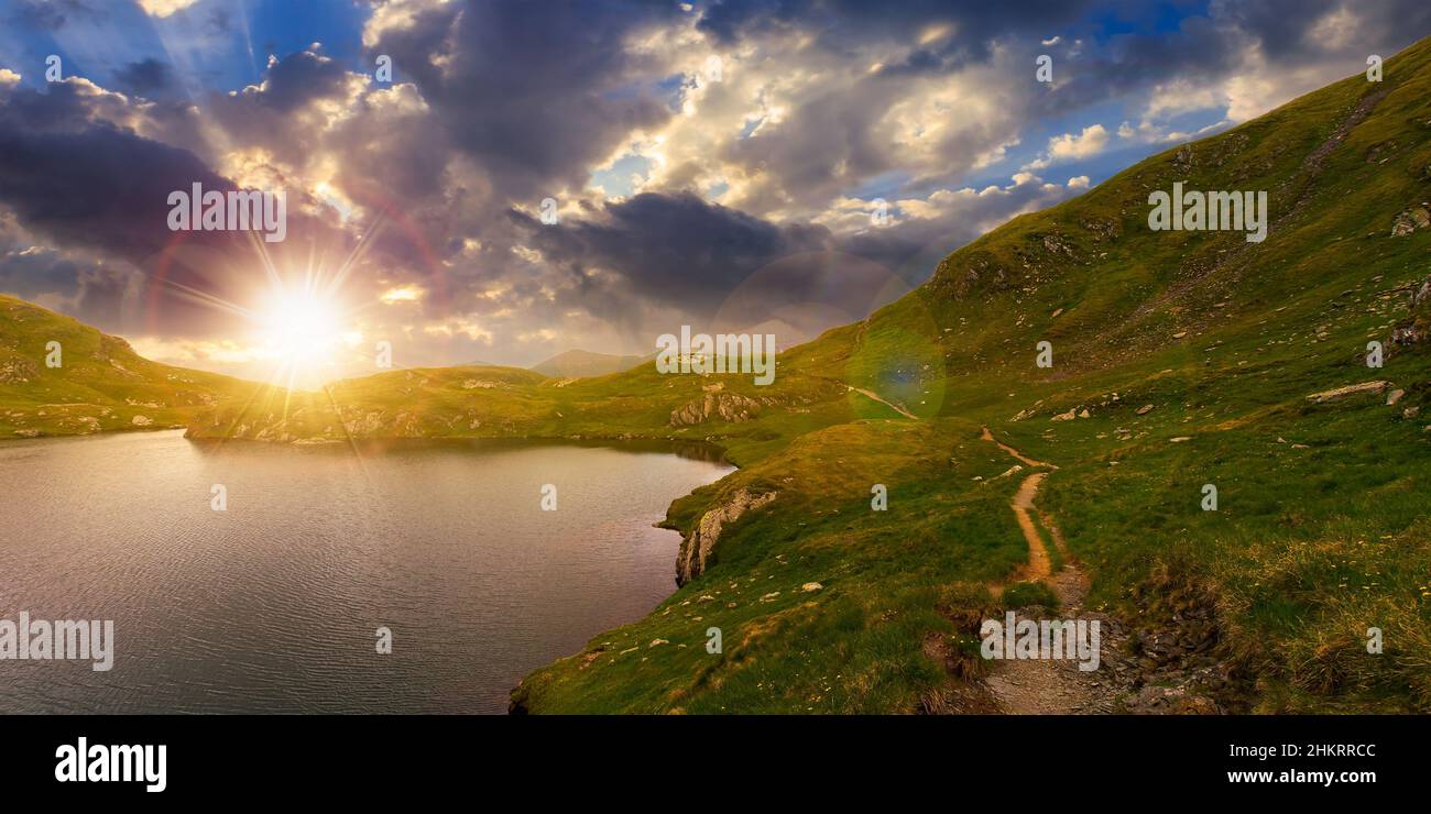 mountain landscape with lake in summer at sunset. beautiful travel destination. scenic nature scene in evening light. outdoor adventure in green envir Stock Photo