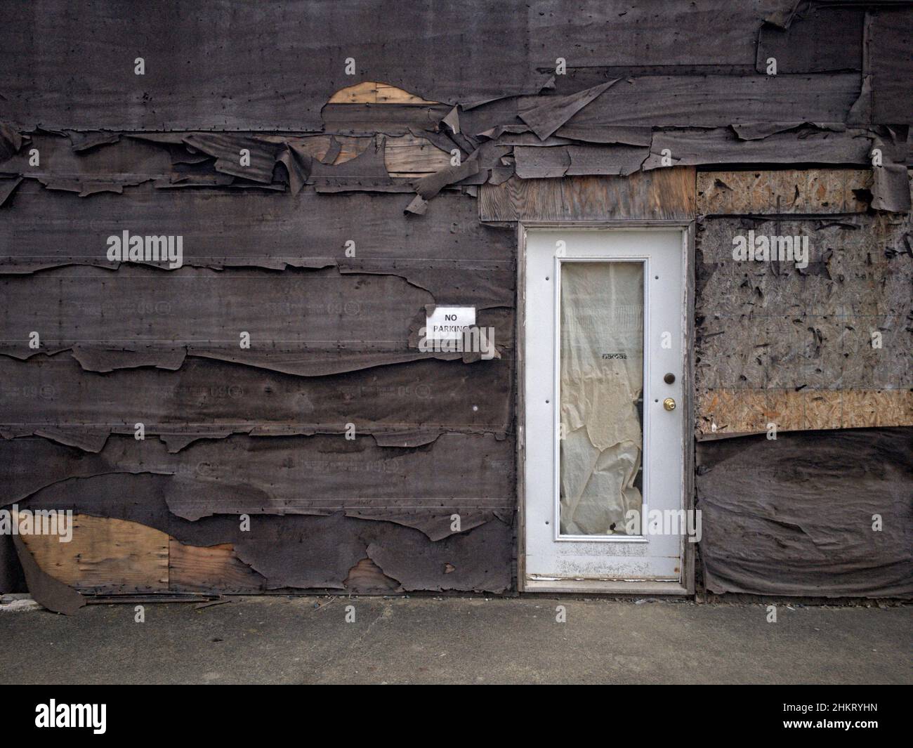 Weathered and peeling tar paper or building paper peels away from 