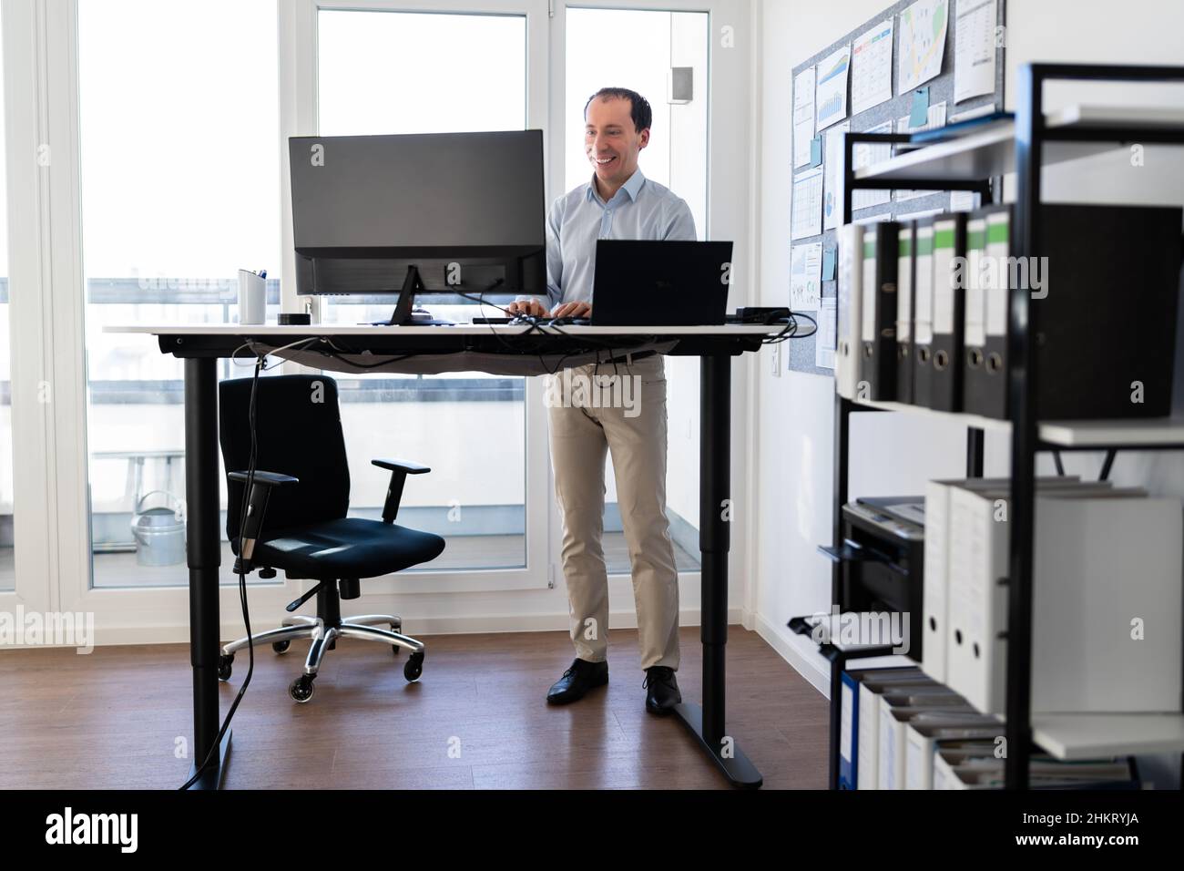 Man Using Adjustable Height Standing Desk In Office For Good Posture