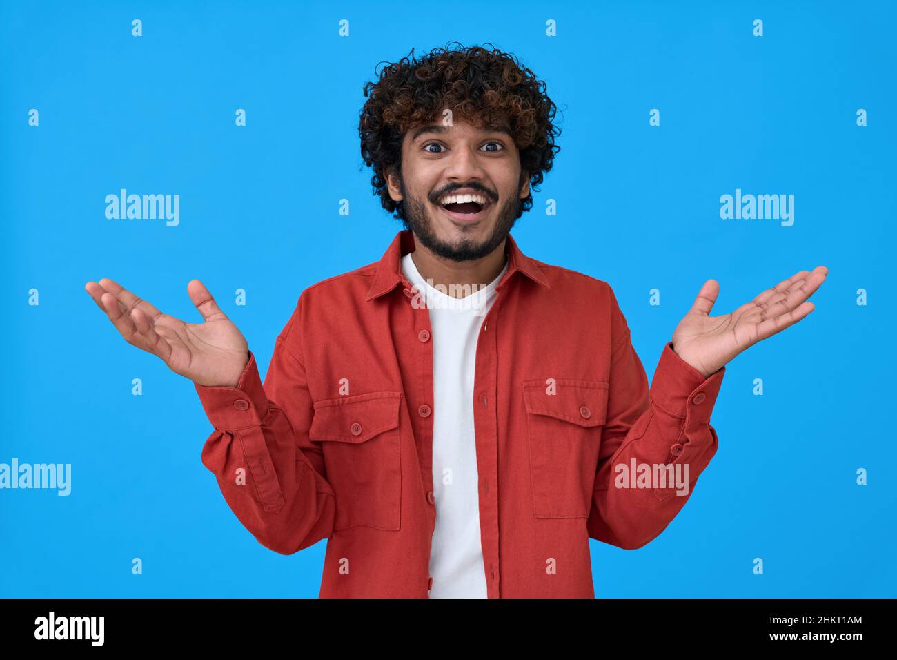 Surprised excited young indian man isolated on blue background. Stock Photo