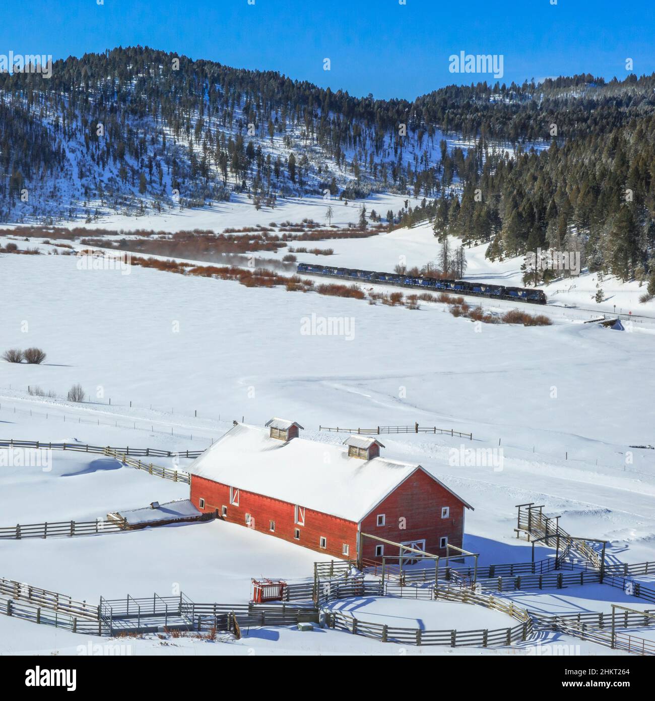 red barn and train in winter in the dog creek valley near elliston, montana Stock Photo