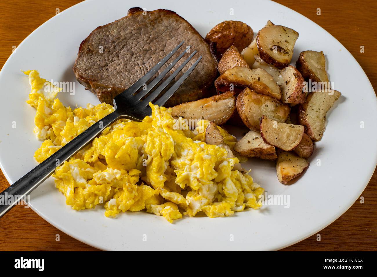 steak served with scrambled eggs and home fries Stock Photo - Alamy