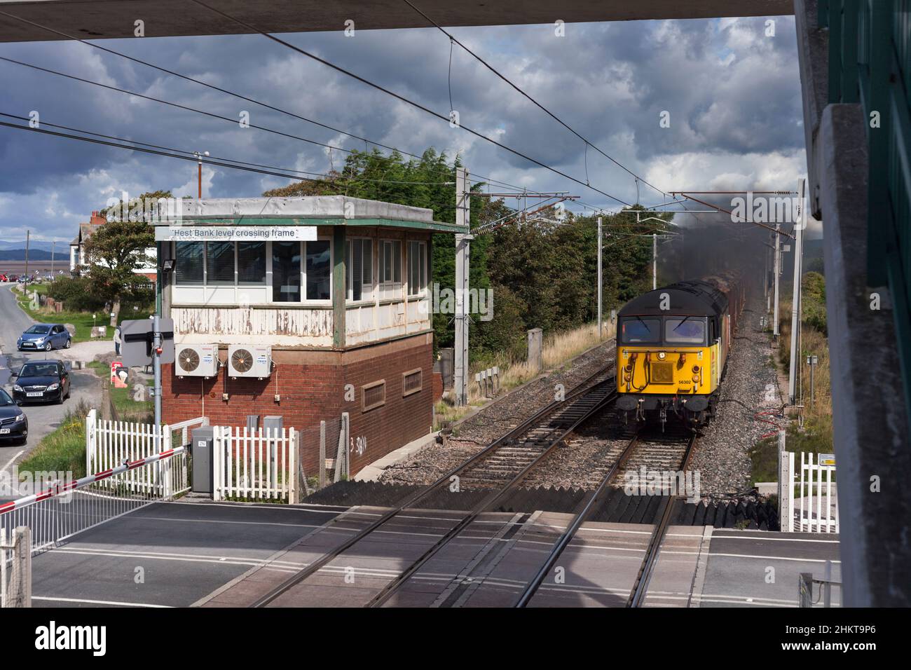 Colas Rail Freight class 56 locomotive passing the closed signal box at Hest Bank level crossing on the west coast mainline in Lancashire Stock Photo