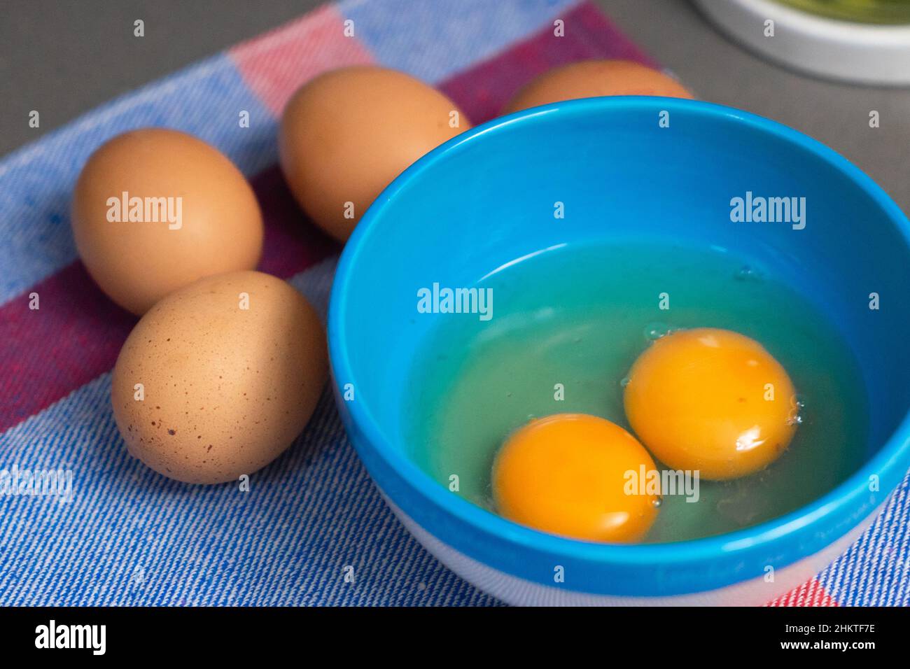 two egg yolks in a blue bowl Stock Photo