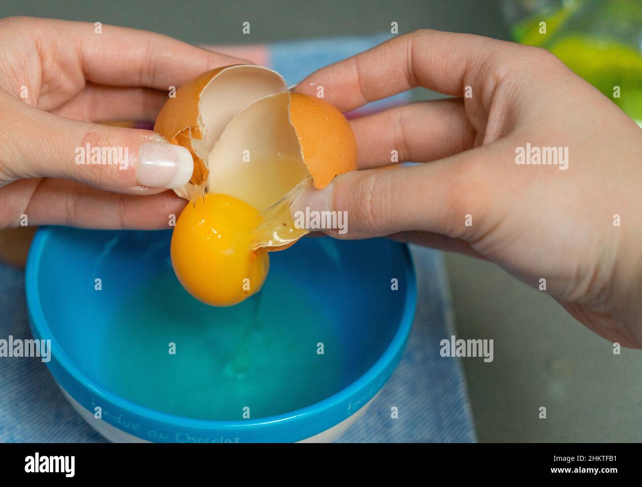 yolk inside a broken egg falling in a bowl Stock Photo