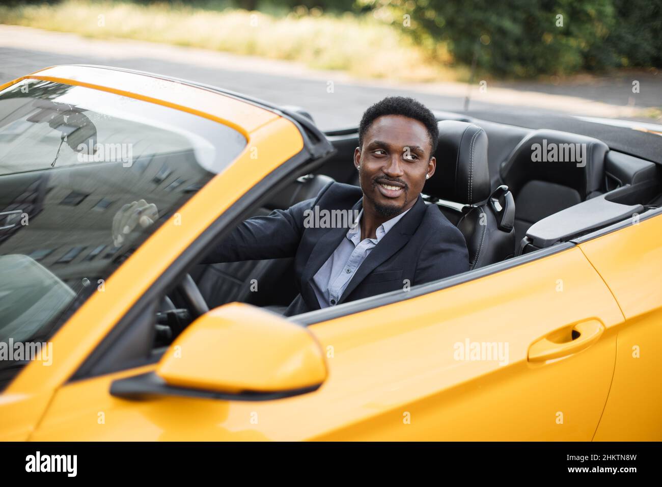 Car side window. Young handsome bearded African businessman driver