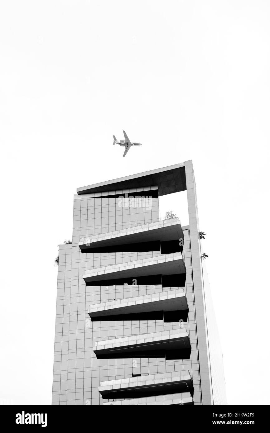 The plane flies over the house. Stock Photo