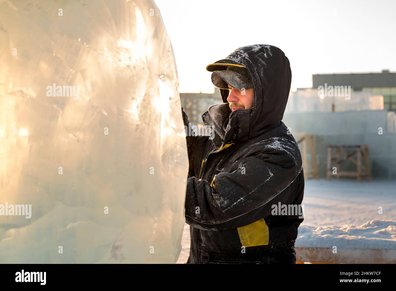 The sculptor cuts an ice figure out of an ice block with a chisel Stock ...