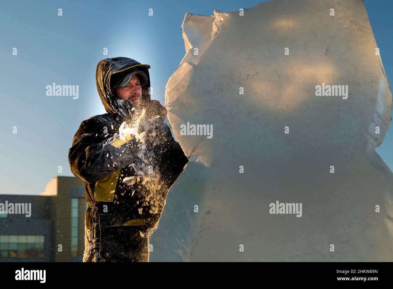The sculptor cuts an ice figure out of an ice block with a chisel Stock ...