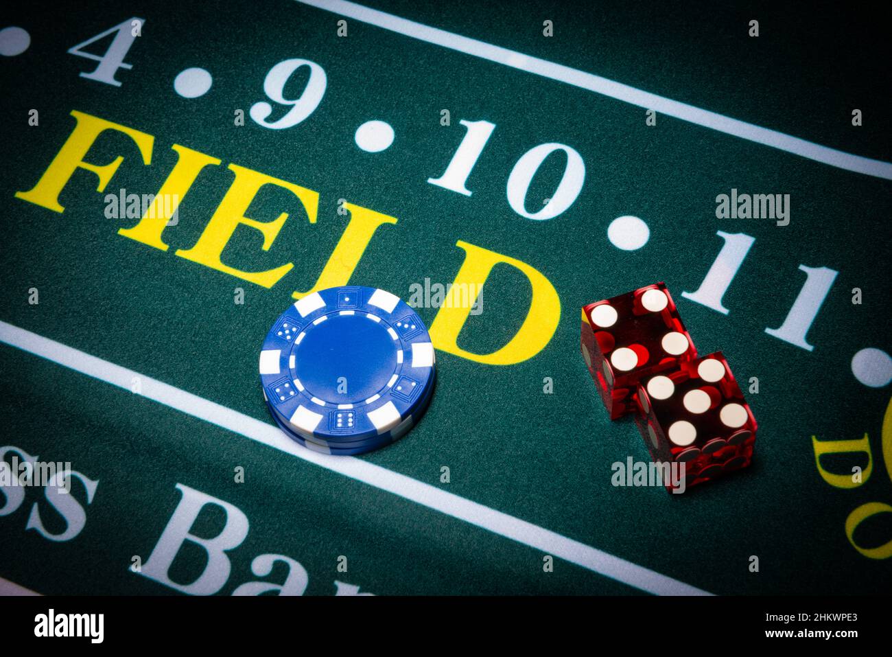 Casino-style dice and chips sit on the field space of a craps table. Stock Photo