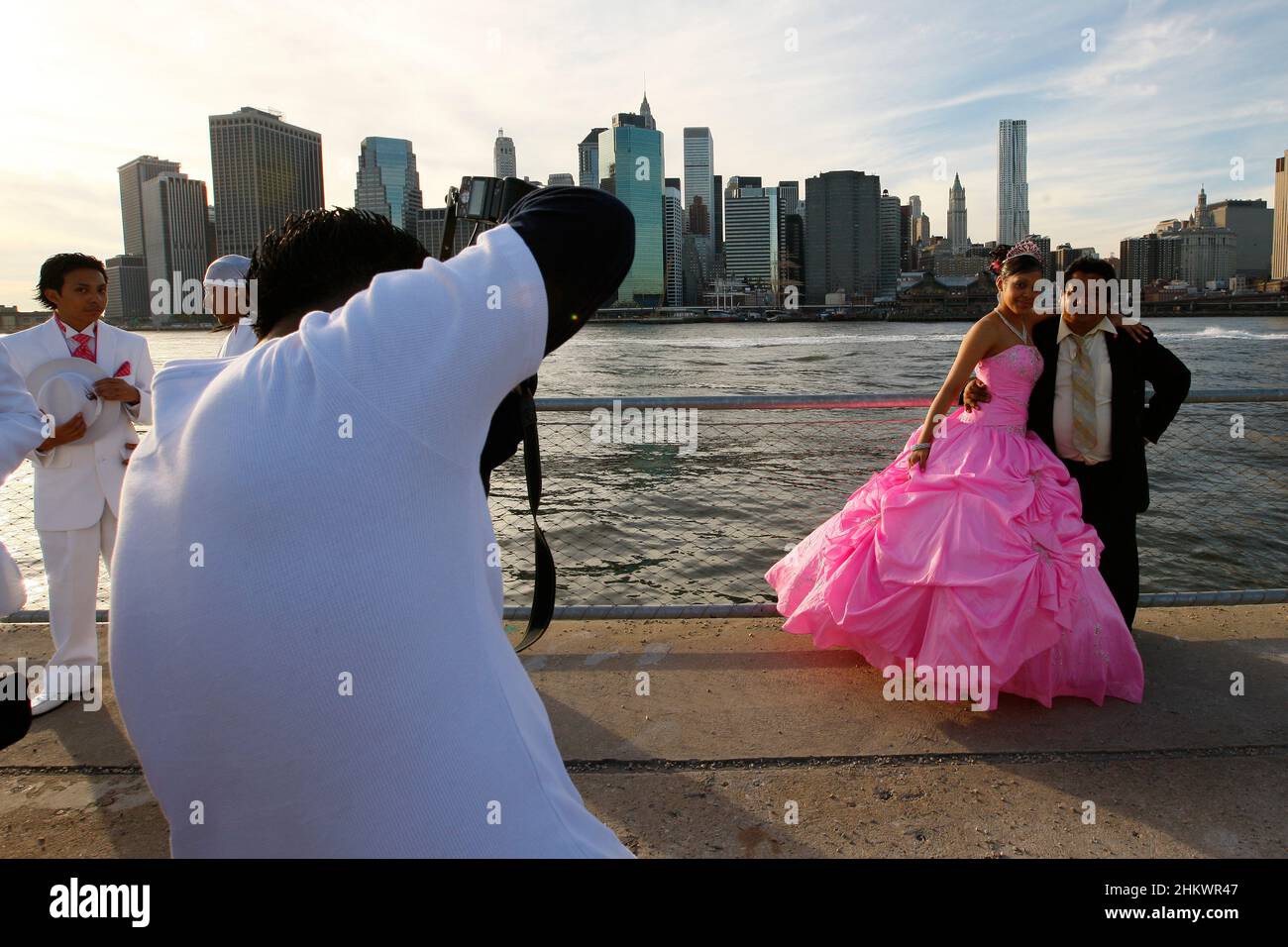 A Quinceañera celebration party are posing for photos in the Brooklyn Bridge Park. Stock Photo