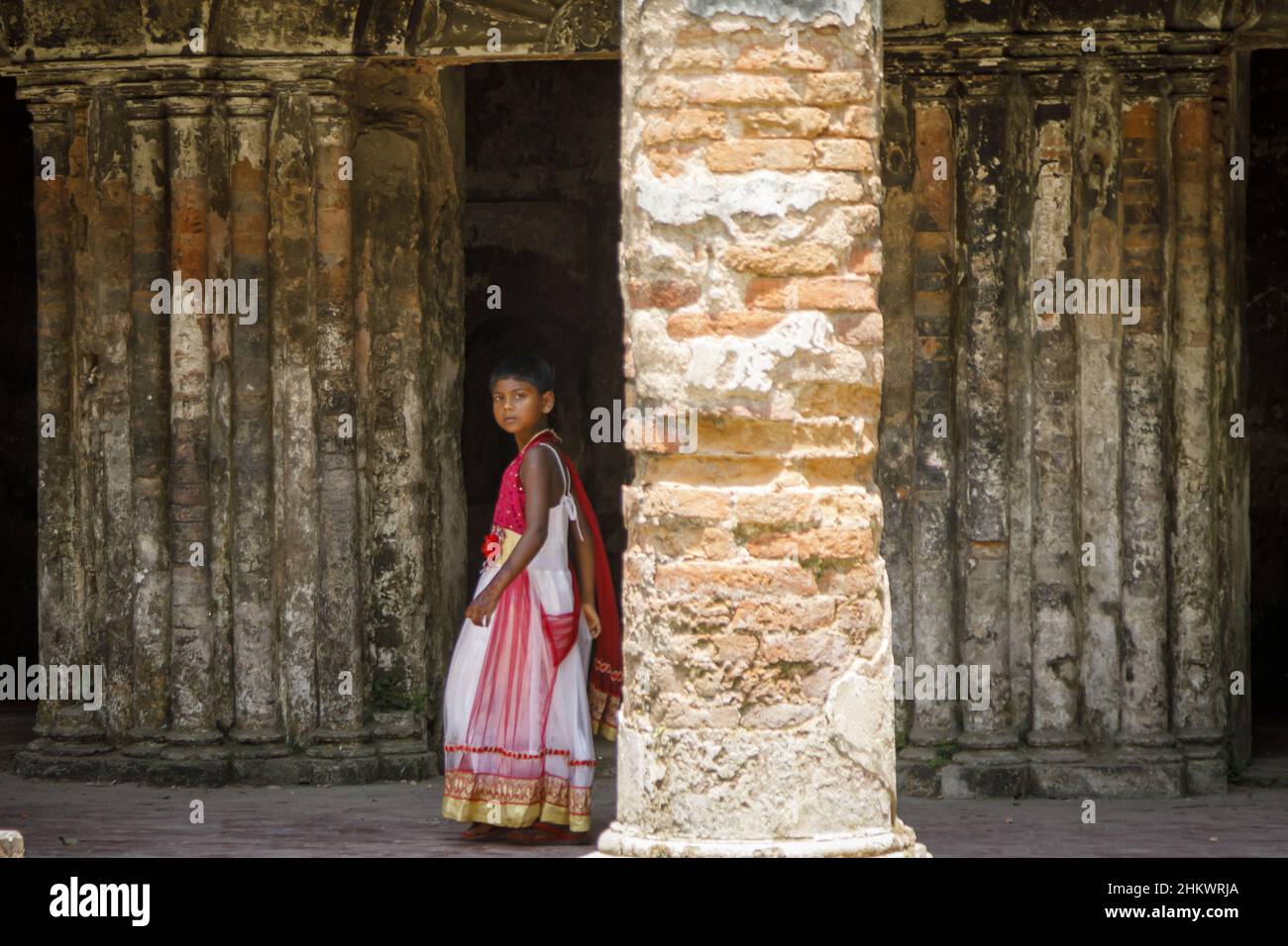 A young girl walking in the ruins of the Teota Zamindar Palace in the Manikganj district. The palace, believed to be around 300 years old, had more than 50 rooms originally. Stock Photo
