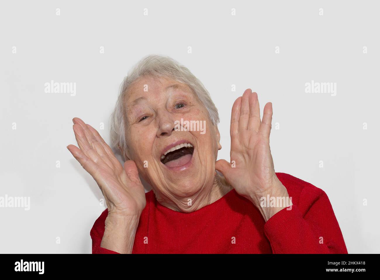 The portrait of a surprised senior woman over white studio background Stock Photo