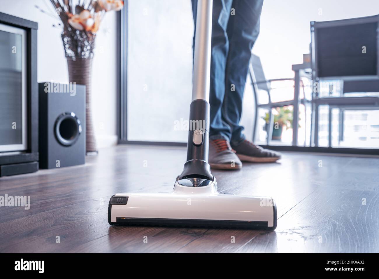 Man cleaning the house with a portable vacuum cleaner Stock Photo