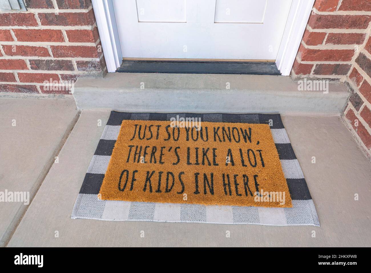 Statement doormat on a concrete flooring with checkered frames Stock