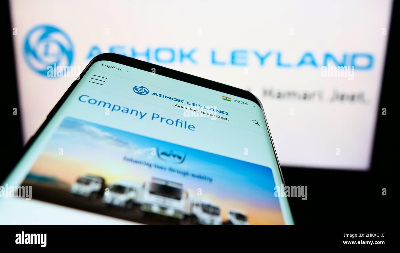 Smartphone with webpage of Indian automotive company Ashok Leyland Ltd. on screen in front of business logo. Focus on top-left of phone display. Stock Photo