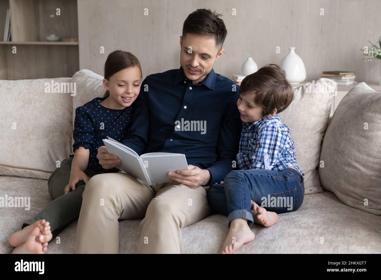 Loving father reading book to little son and daughter Stock Photo